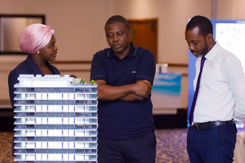 Oriental Royal Estates representatives and visitors discussing a residential development model