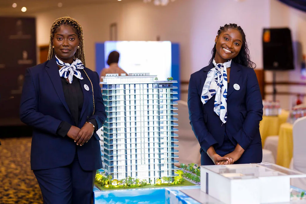 Oriental Royal Estates representatives standing beside a residential development model