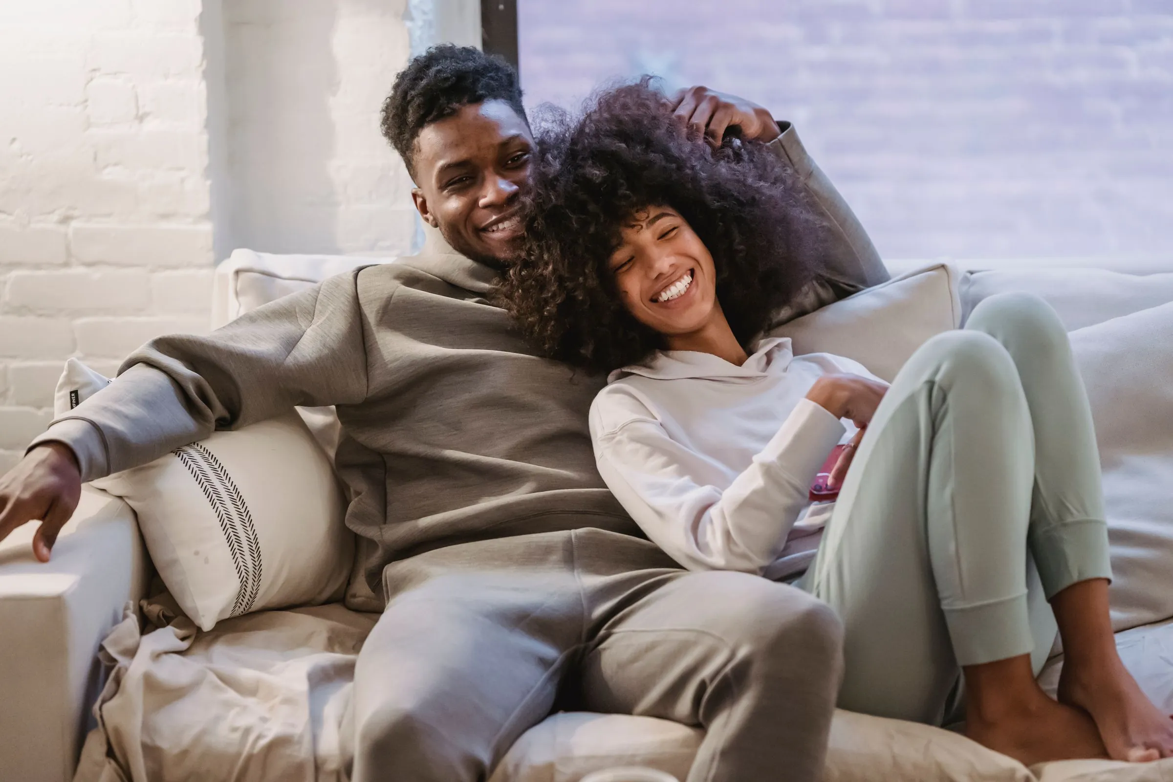 A young couple sharing a relaxed moment in their light-filled home