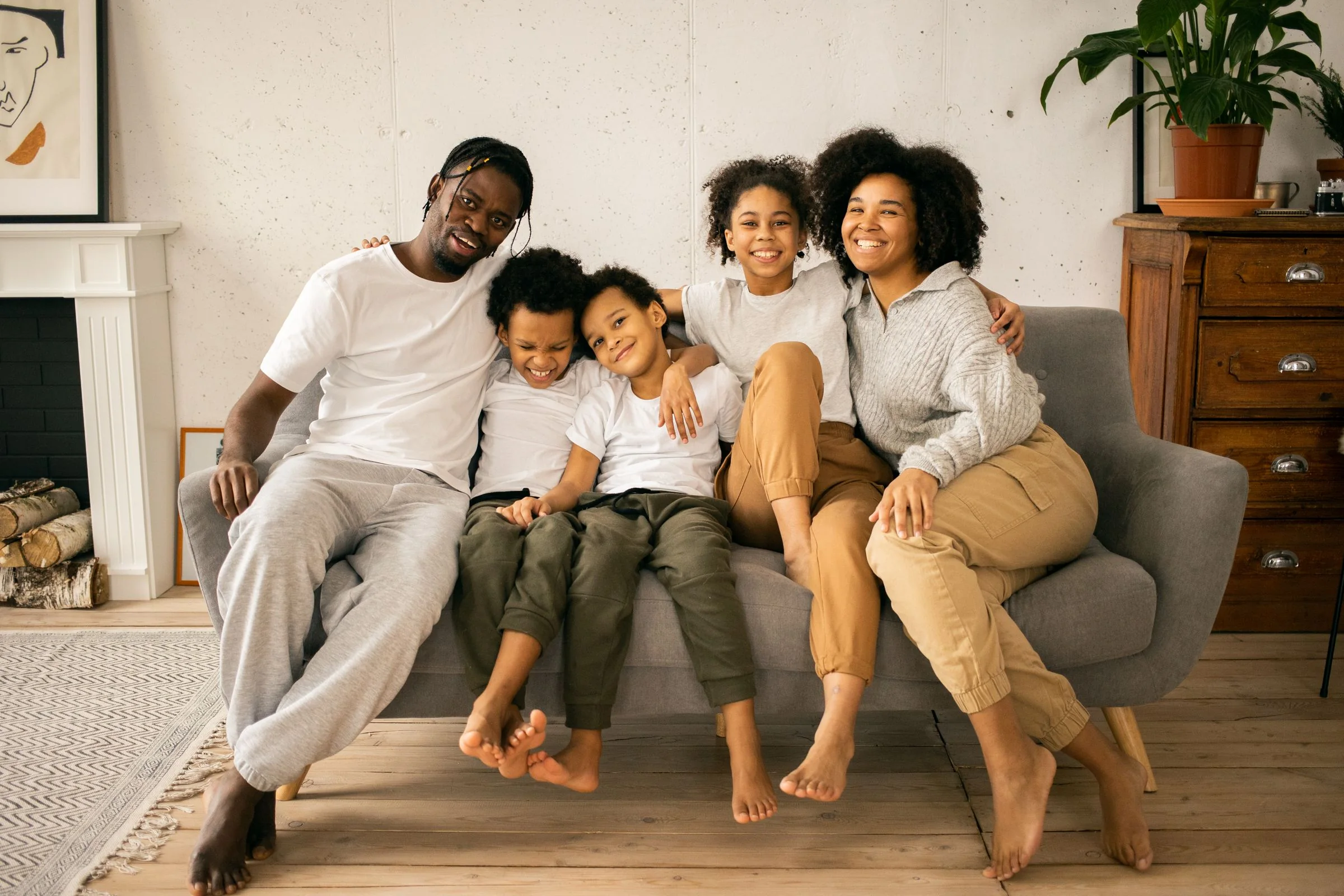 A family relaxing together on a sofa in a bright, welcoming home