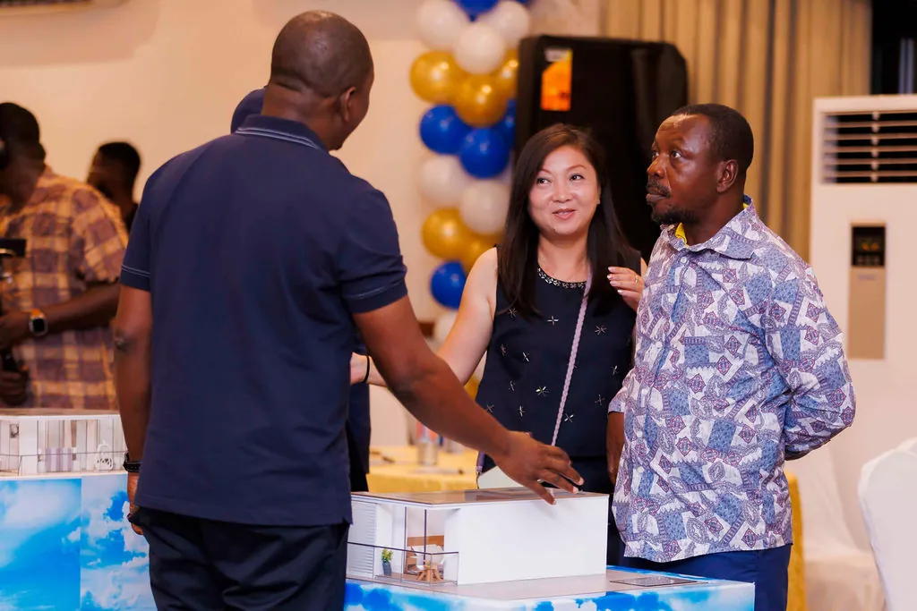 Guests discussing a residential floor plan at the Labadi Beach Apartments presentation